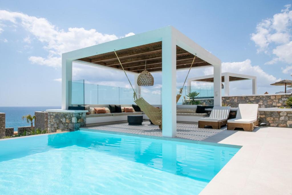 a villa with a swimming pool and a patio at Elements Villas in Lartos