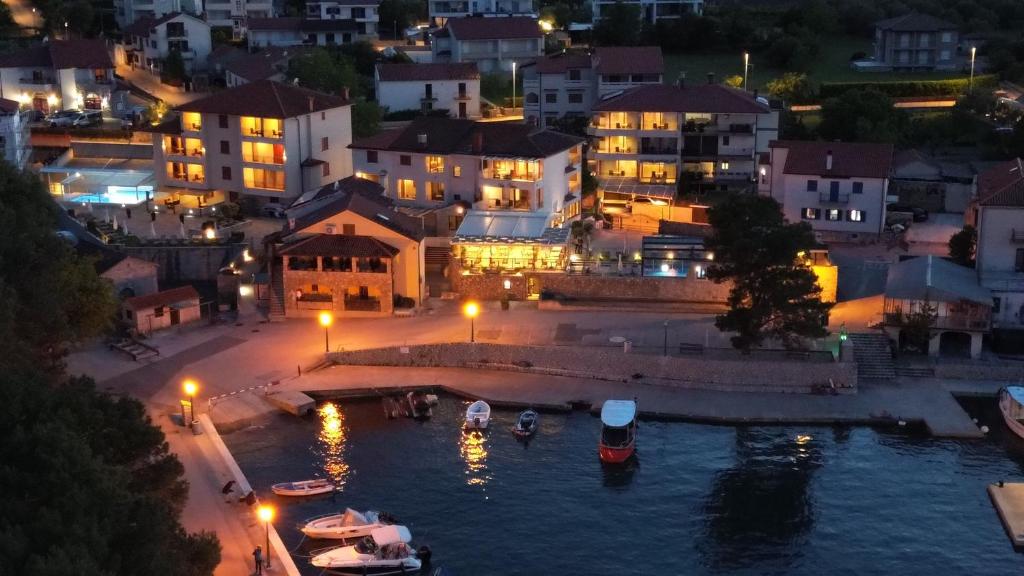 a city at night with boats in the water at Boutique Resort Villa VISTA in Malinska