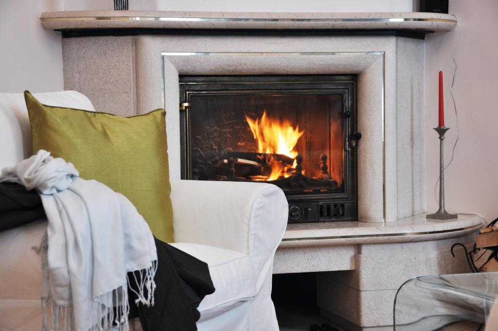 a fireplace with a white chair and a fire place at Business Home Vienna in Vienna