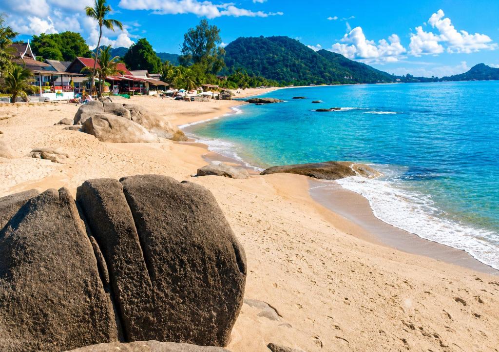 a beach with rocks in the sand and water at Paradise Bungalows Lamai Beach in Lamai