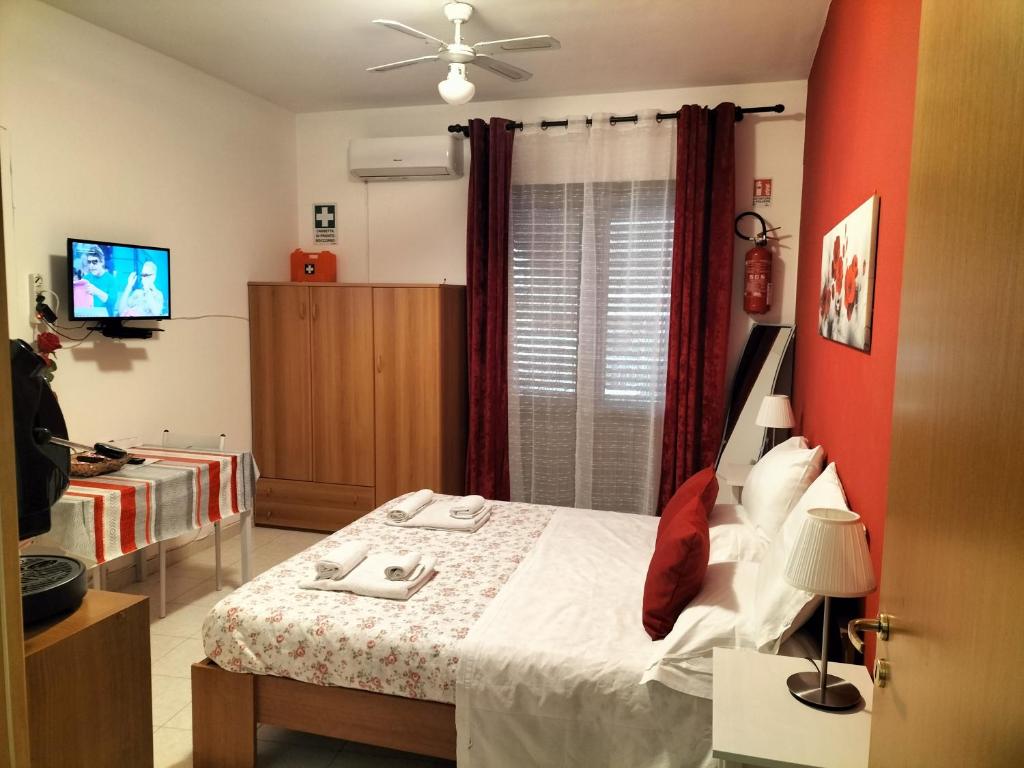 a bedroom with a bed and a tv in it at Da Rosa in Letojanni