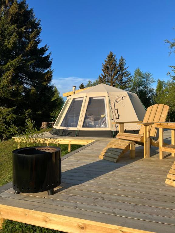 a tent and a grill on a wooden deck at Torshaug glamping in Trondheim