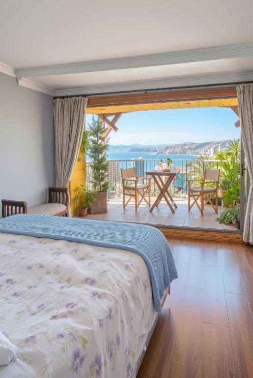 Hotel Boutique Casa Vander في فالبارايسو: غرفة نوم بها سرير وإطلالة على المحيط