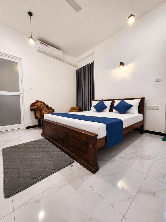 a bedroom with a large bed with blue pillows at Silva Nest Recidencies in Galle