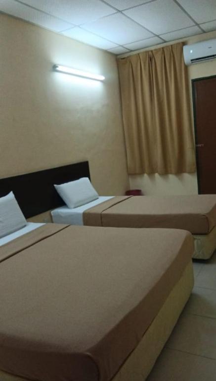 a hotel room with two beds and a window at Hotel The Island in Pangkor