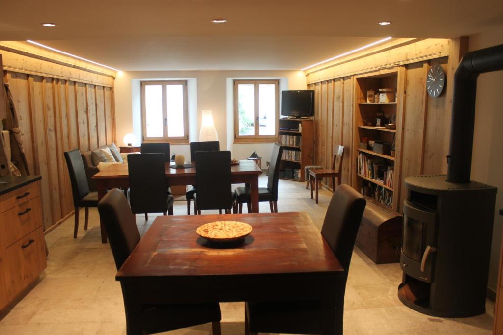 ein Wohnzimmer mit einem Tisch und einem Esszimmer in der Unterkunft L'ancienne Poste - Maison Napoléon in Bourg-Saint-Pierre