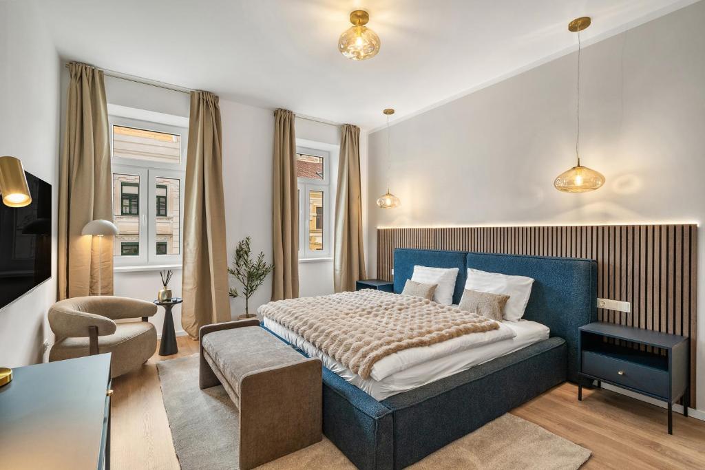 a bedroom with a blue bed and a chair at dreamfactory Residence - Royal Westside in Vienna