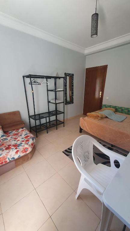 a bedroom with two beds and a table and a chair at Sweet Room in Casa in Casablanca