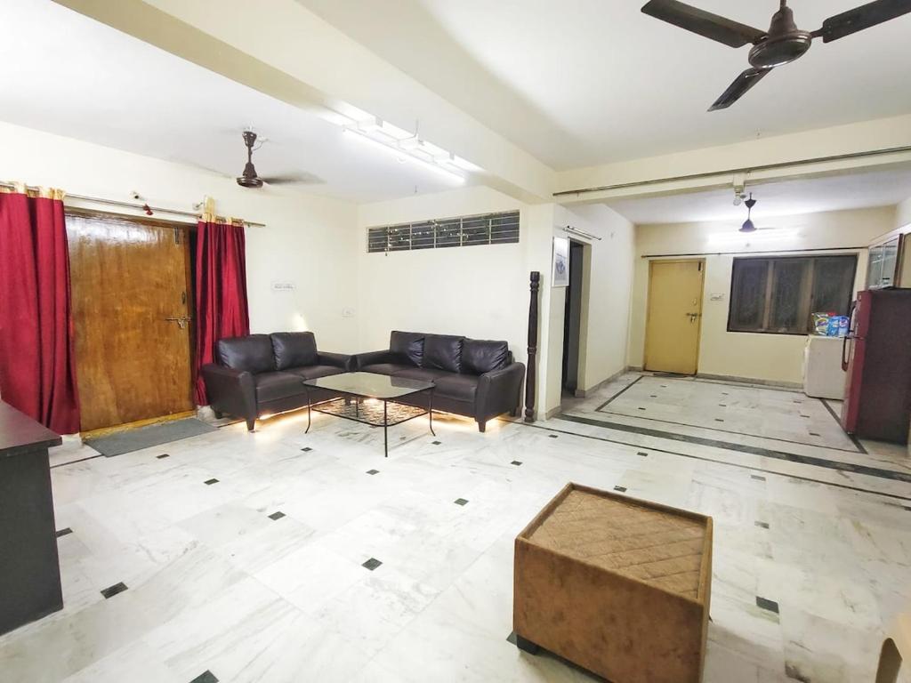 a living room with a couch and a table at Ravuri's Residency in Hyderabad