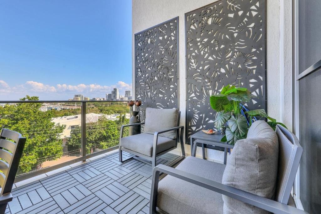 a balcony with chairs and a view of the city at The Skyline Lookout Pool, BBQ, FREE parking in Stuart Park