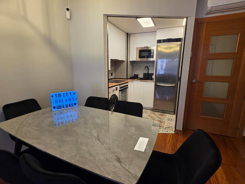 a dining room table with chairs and a kitchen at Sweet Dreams Úbedas in Talavera de la Reina