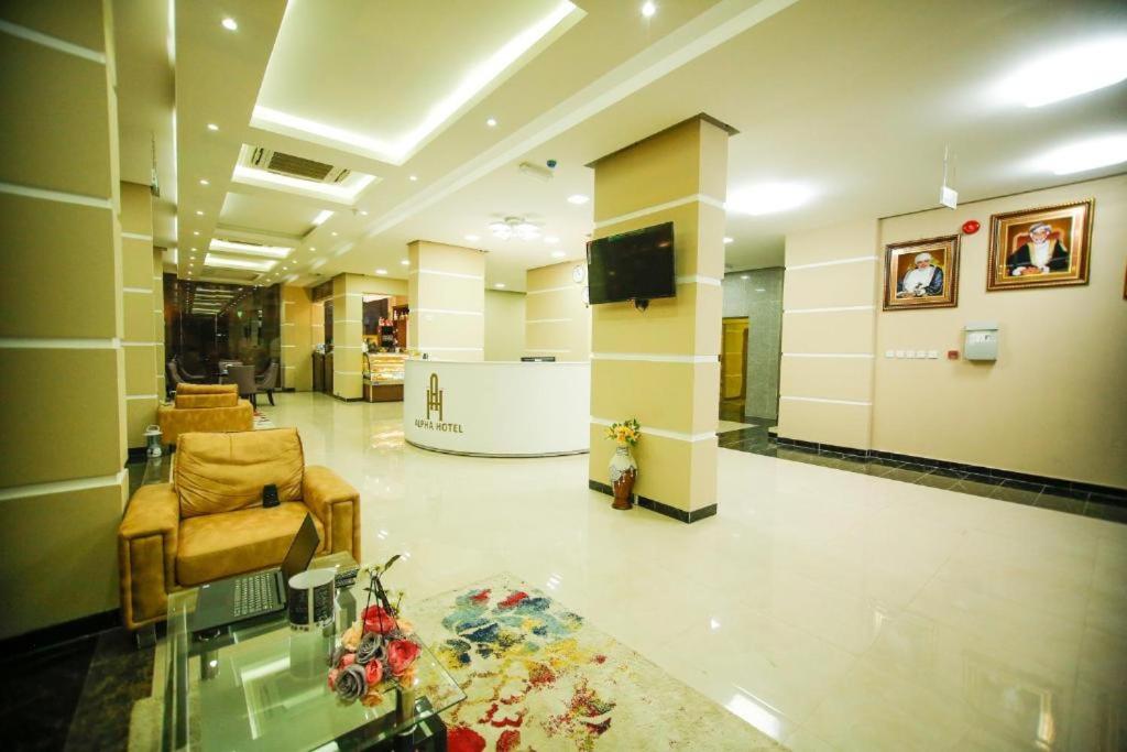 a lobby with a waiting room with chairs and a tv at Alpha Suites Salalah in Salalah