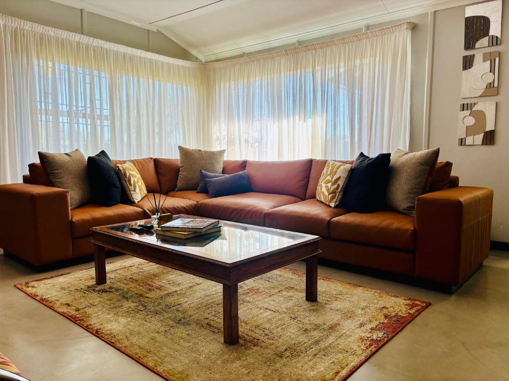 a living room with a brown couch and a coffee table at Homestead in Kempton Park