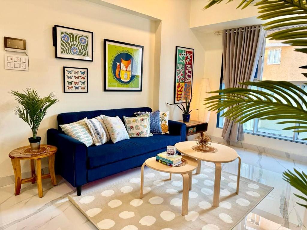 a living room with a blue couch and a table at Sheetal Vaibhav 902 in Mumbai