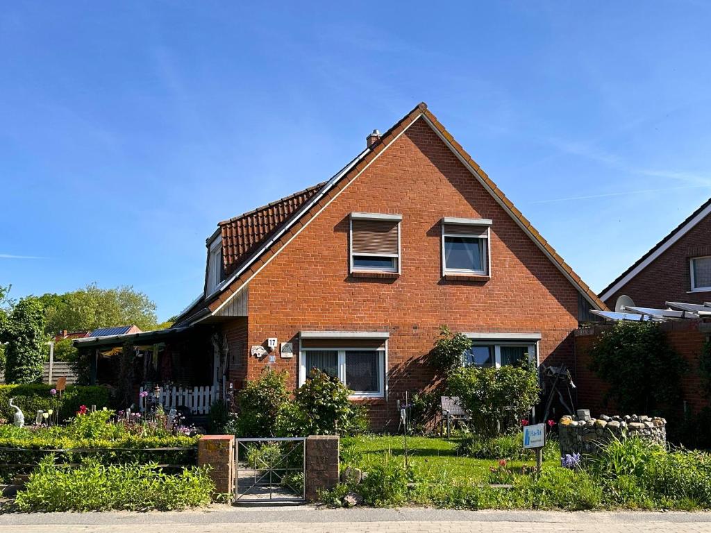 a red brick house with two windows and a yard at Ferienwohnung-Wildblume in Petersdorf auf Fehmarn
