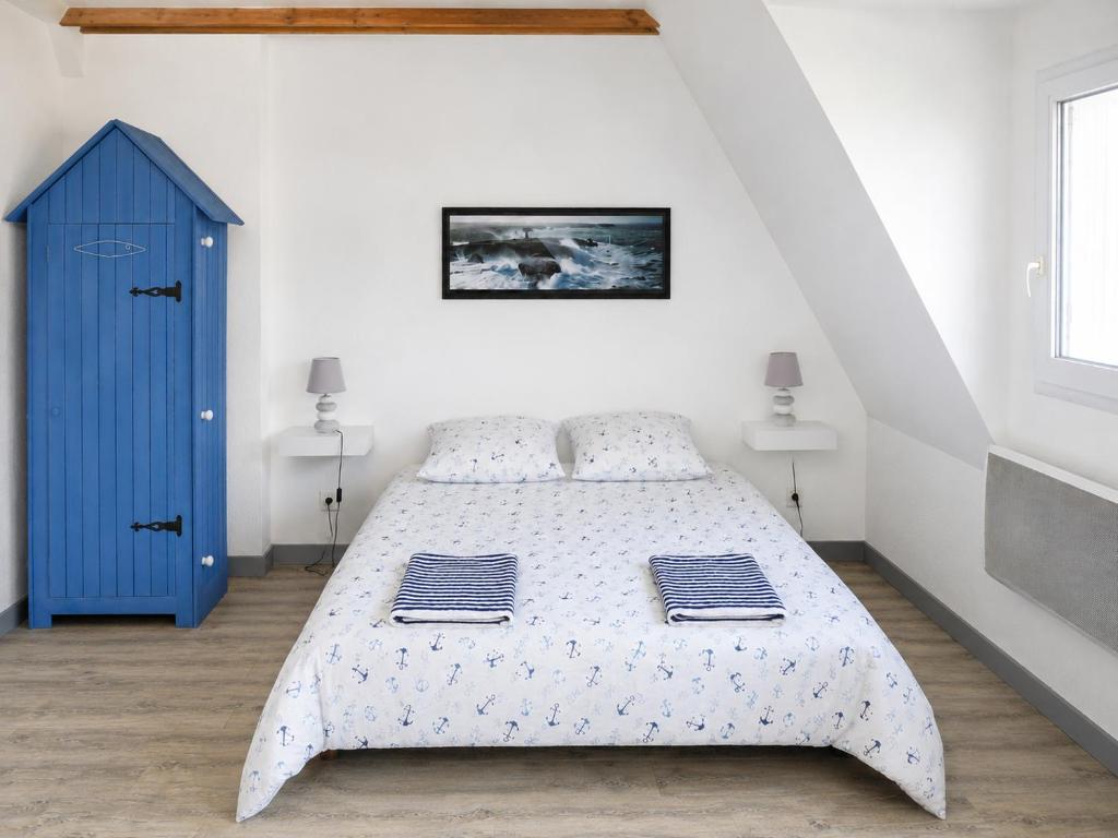 a bedroom with a bed and a blue cabinet at Donemat in Arzon
