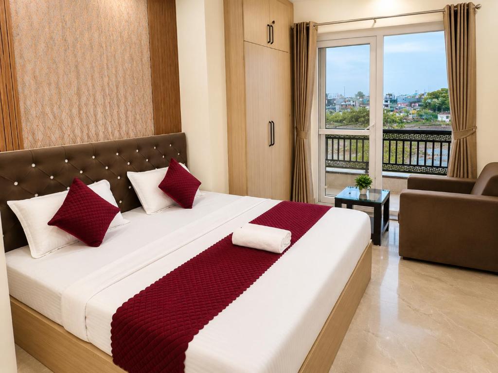 a bedroom with a large bed with red pillows at Hotel Pratishtha in Rishīkesh