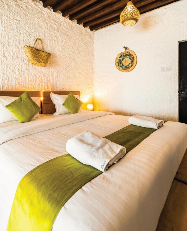 a bedroom with a bed with two towels on it at SAMA Al Khutaim-Heritage Home in Nizwa