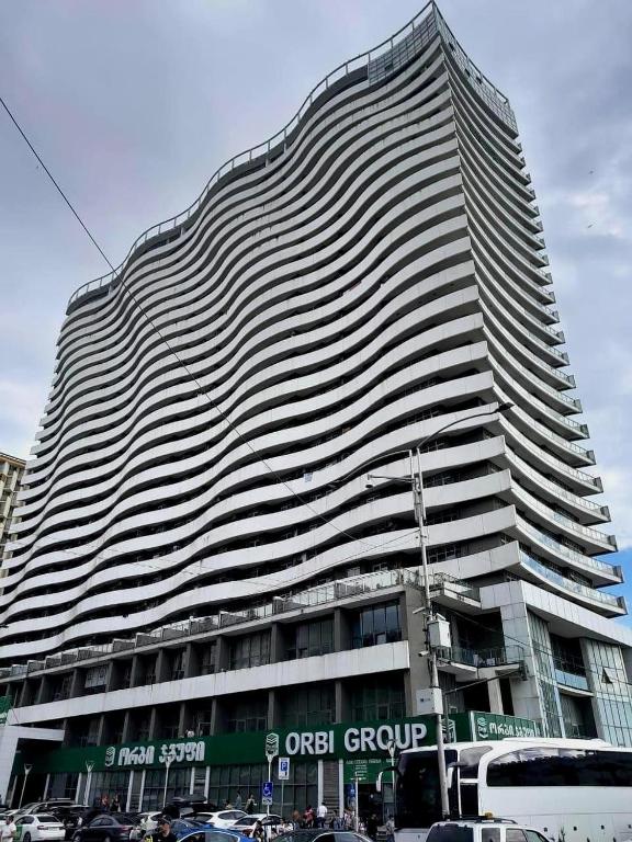 a tall building with cars parked in front of it at Orbi Residence in Itʼkhvisi