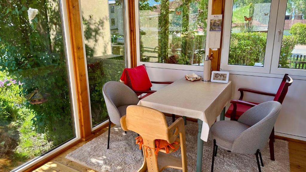 a table and chairs in a room with windows at Ferienwohnung Juttchen in Roßleben