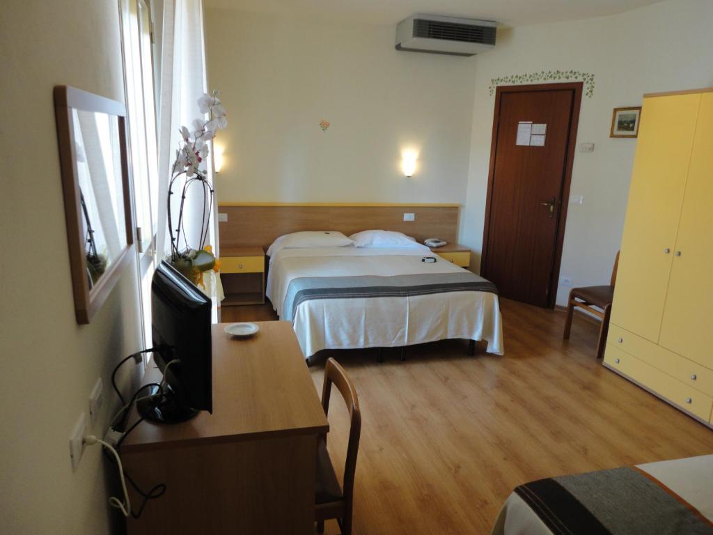 a hotel room with two beds and a desk at Hotel Mariani in Lido di Camaiore