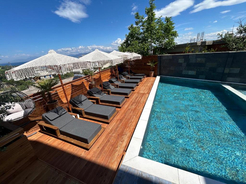a swimming pool with lounge chairs next to a swimming pool at Vila Jeti in Ksamil