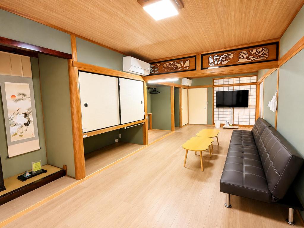 a living room with a couch and a tv at Joynest TAKAMATSU in Takamatsu