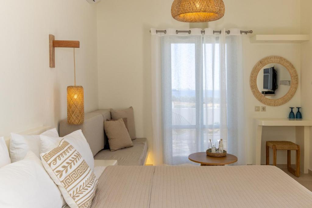 ein Wohnzimmer mit einem weißen Sofa und einem Fenster in der Unterkunft Anthea Hotel in Tinos