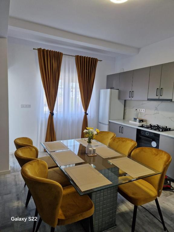 a kitchen with a dining room table and yellow chairs at Apartament 3D in Fălticeni