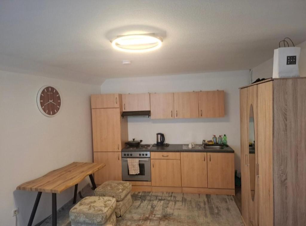 a kitchen with wooden cabinets and a table and a stove at Cozy Apartment Koblenz in Koblenz
