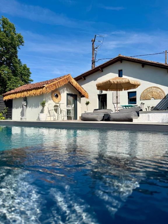 a house with a swimming pool in front of a house at Suite Vendôme - Elégance, Terrasse avec accès Piscine in Villeréal