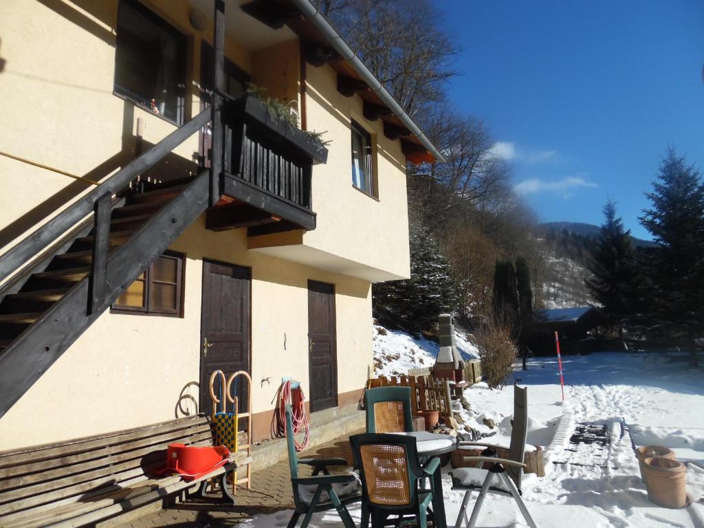 ein Gebäude mit Balkon und Tischen und Stühlen im Schnee in der Unterkunft FeWo Katie in Radenthein