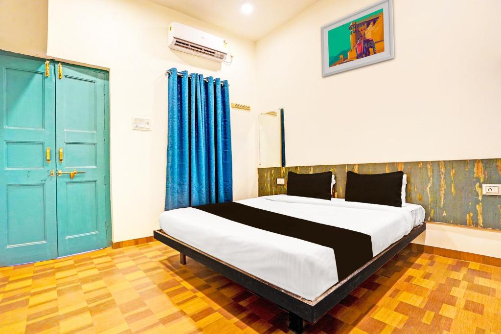 a bedroom with a large bed and blue doors at Super Hotel O THE VANTAGE INN in Nagpur