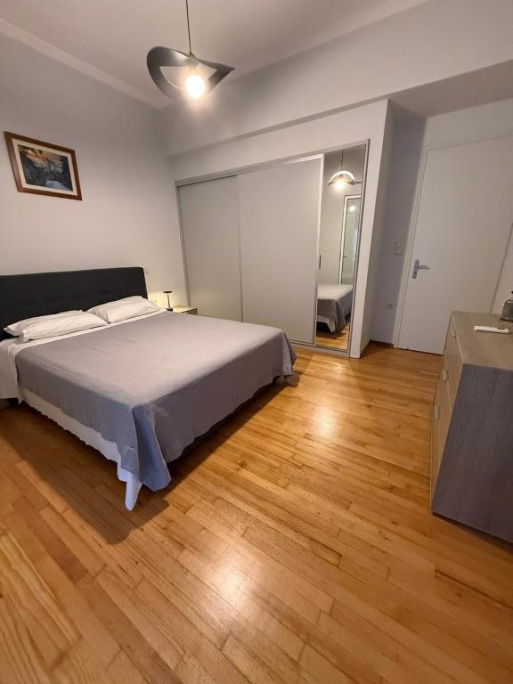 a bedroom with a bed and a wooden floor at Skyfall with a large balcony and FREE parking in Central Kiato in Kiaton