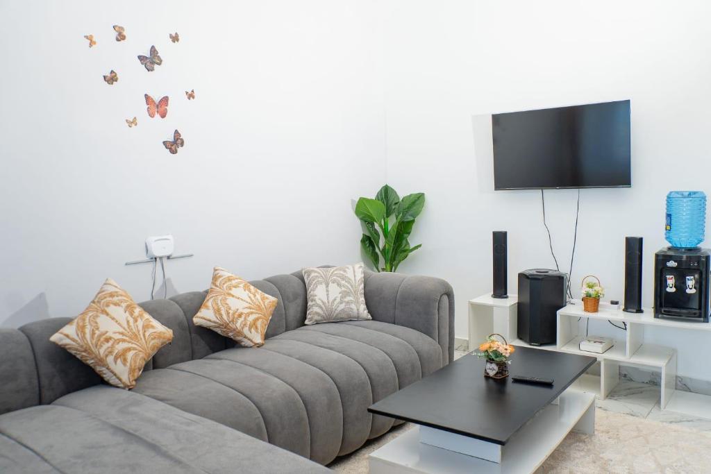 a living room with a grey couch with butterflies on the wall at Malindi White in Malindi