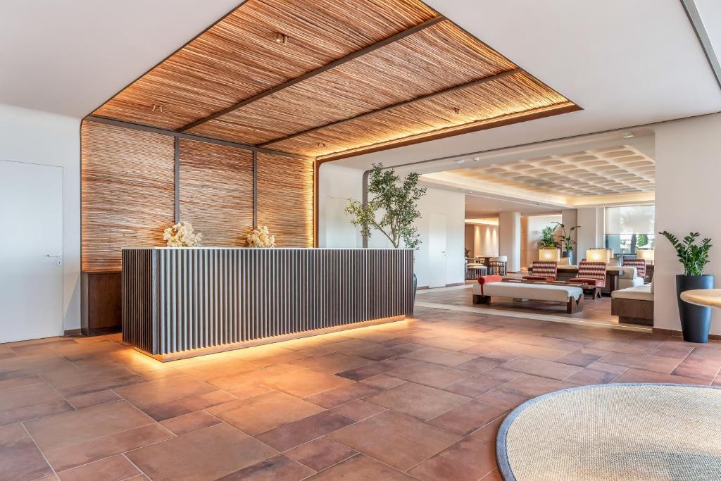 an office lobby with a reception desk and tables at Kouros Palace Active Lifestyle Hotel in Mastihari