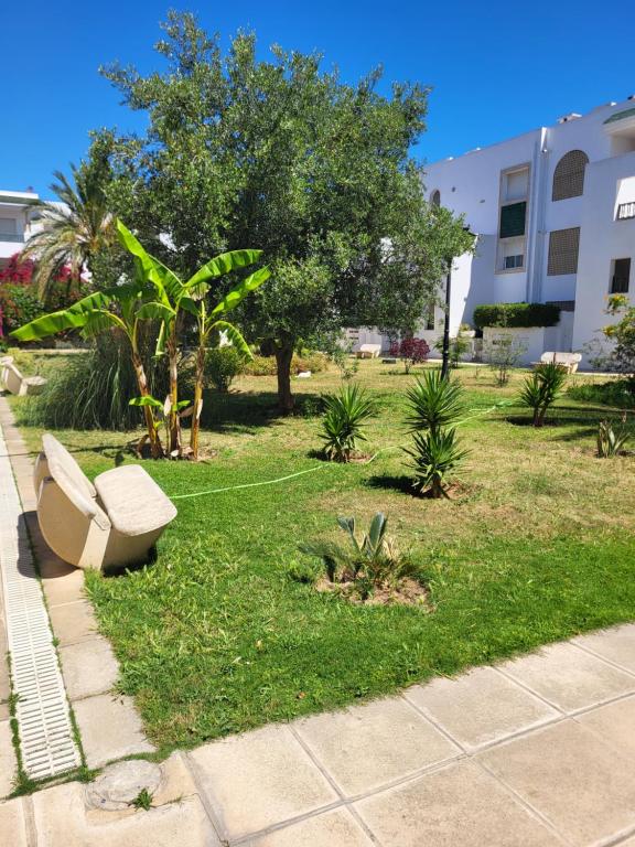 a park with a bench sitting in the grass at Duplex el 3ebdelleyya en face tennis club la marsa in Tunis
