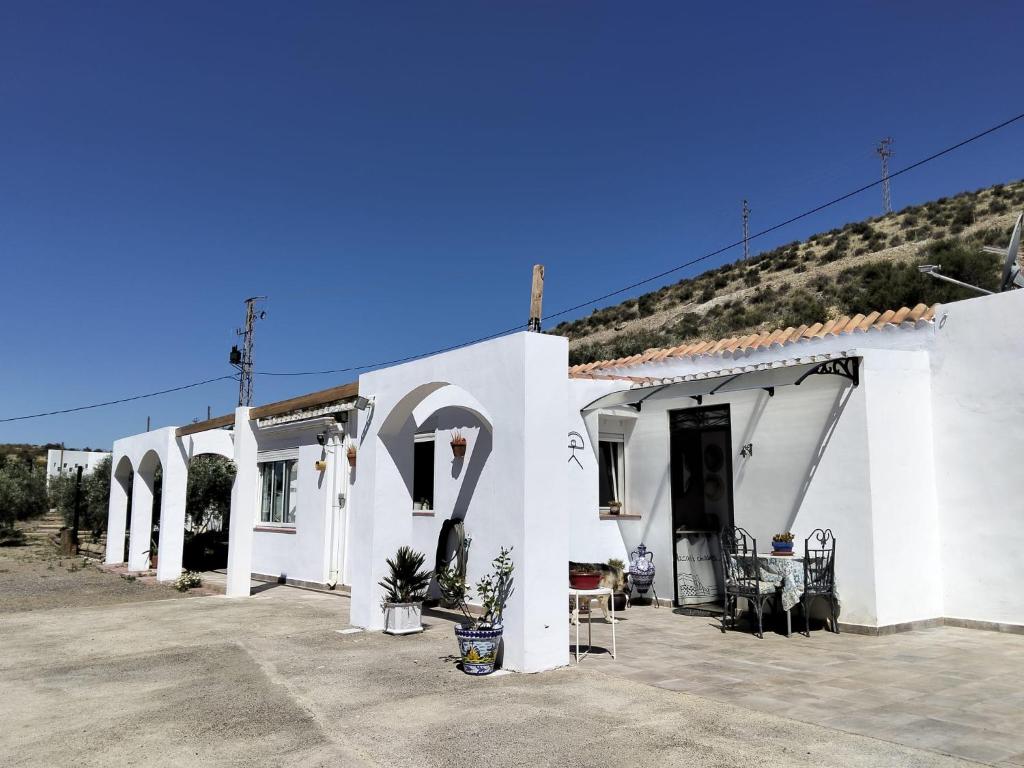 a white building with a lot of chairs outside at Finca Indalopez in Tabernas