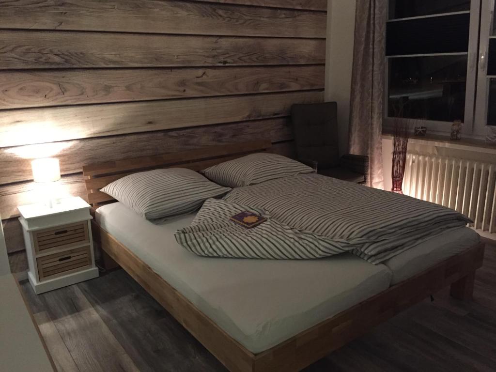 a bedroom with a bed with a wooden wall at Appartement Moervig in Flensburg