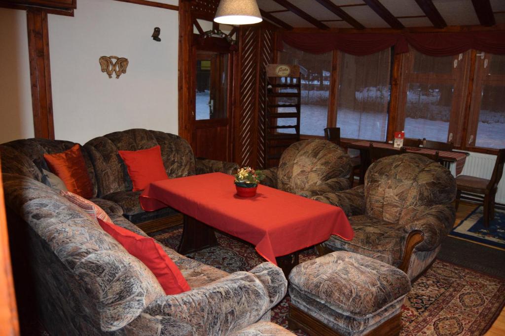 uma sala de estar com sofás e uma mesa vermelha em Persey Villa Borovets em Borovets