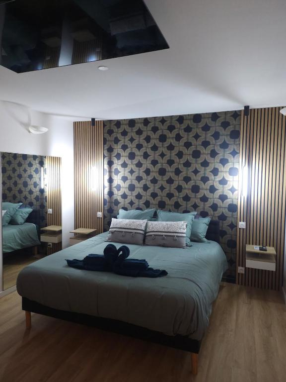 a bedroom with a large bed with a black robe on it at Chambre Standing Ruffec avec Air Climatisé in Ruffec