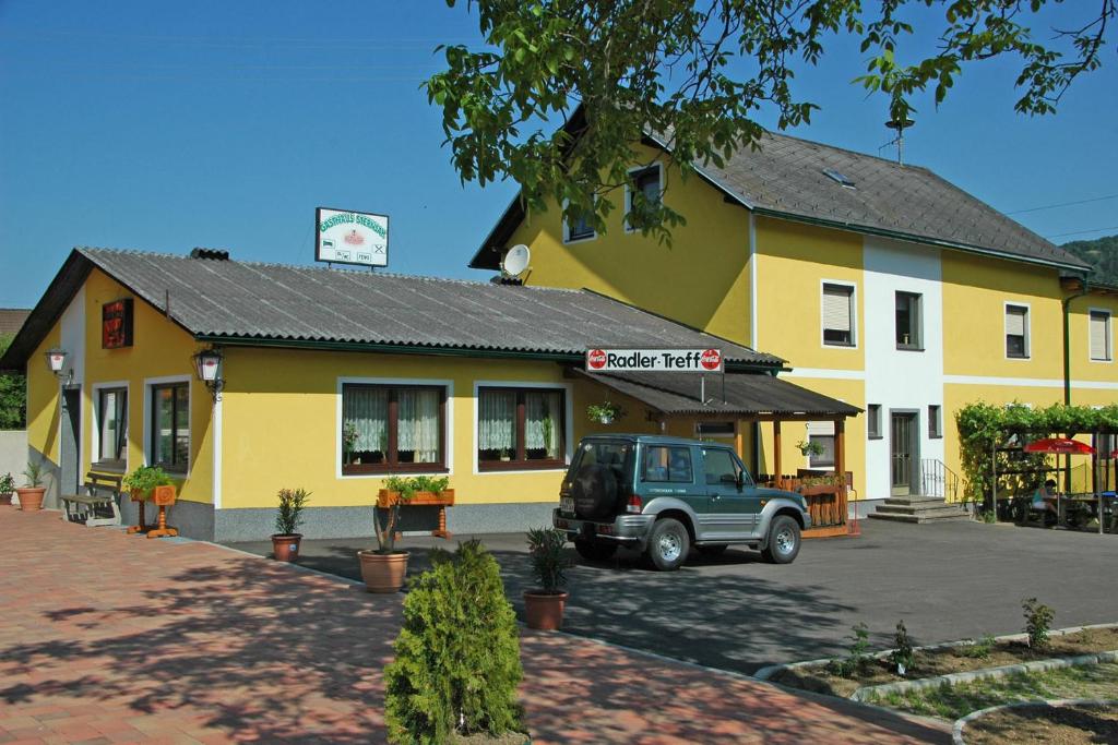 a truck parked in front of a yellow building at Gasthaus Sternjak in Wunderstätten