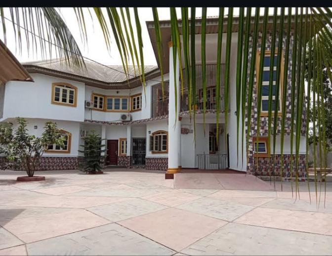 a large white house with a large courtyard at Imtech Luxury Apartments in Uyo