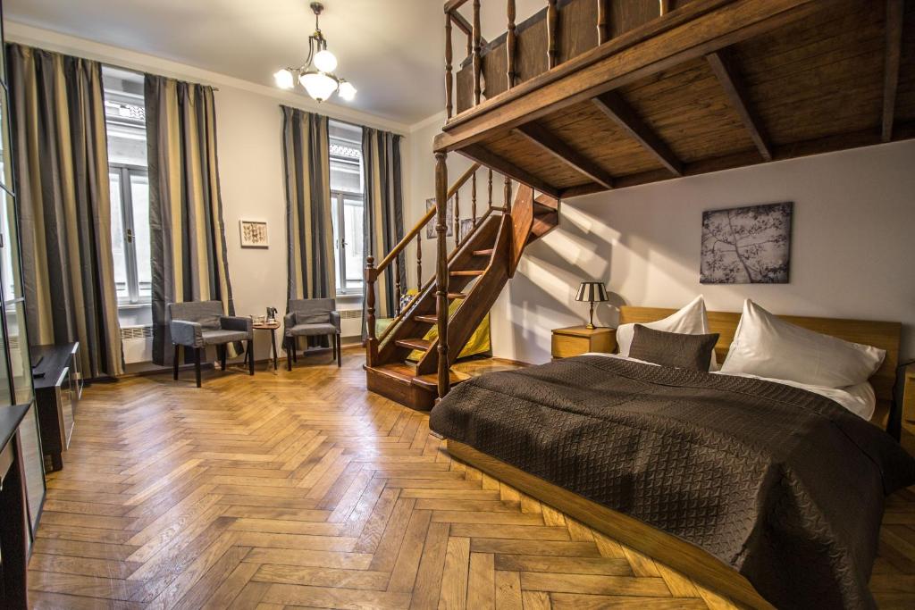 プラハにあるColonial Ruterra 2BDR Apartmentのベッドルーム1室(大型ベッド1台、階段付)