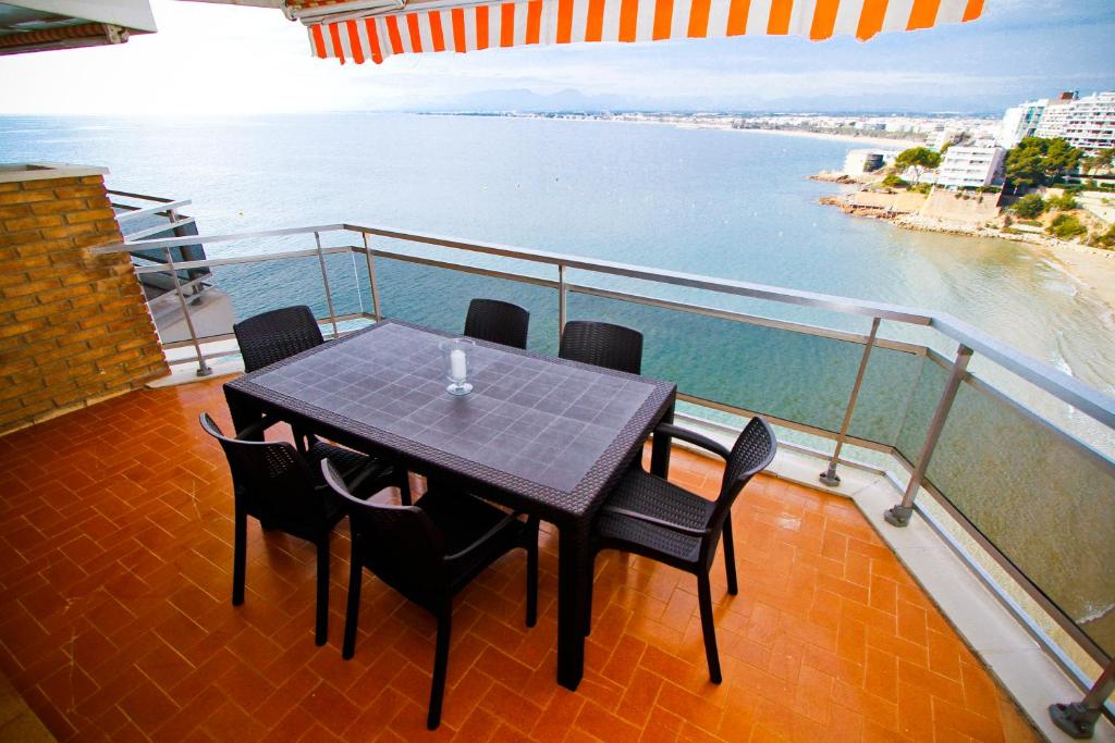 サロウにあるBAHIA I HomeStay by Turismarのテーブルと椅子、海の景色を望むバルコニー