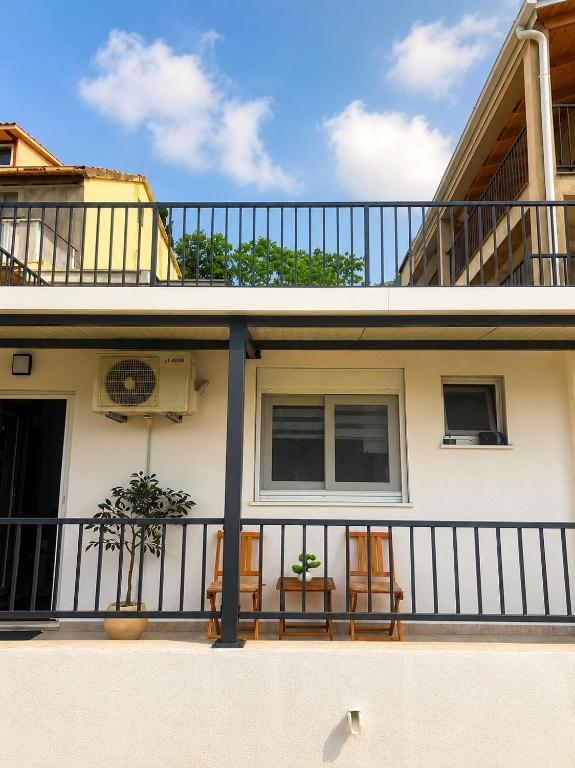 a balcony of a house with two chairs at Christina in Otok