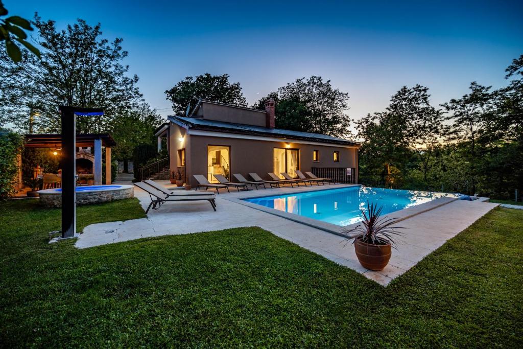 a house with a swimming pool in the yard at Villa Ferlini in Central Istria with private 10000 m2 garden, wellness & family activities on plot in Svetvinčenat