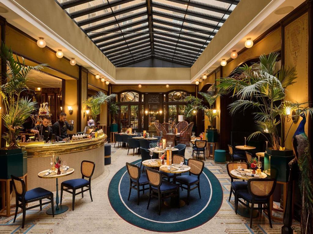 a restaurant with tables and chairs and a bar at l'Echiquier Opéra Hotel Paris - MGallery Collection in Paris