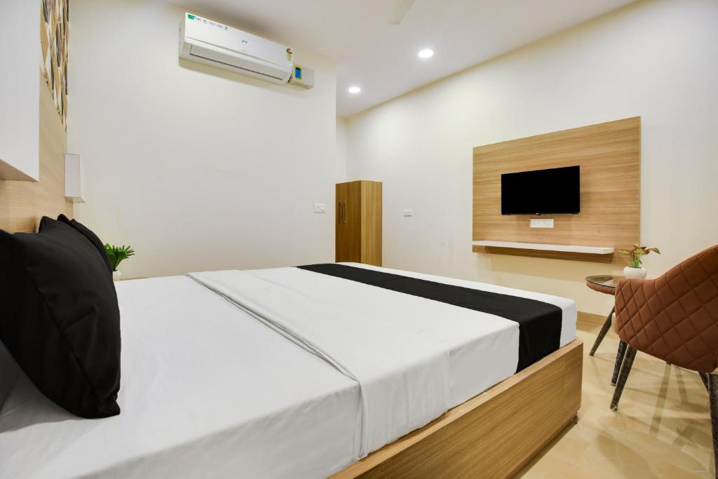 a bedroom with a bed and a flat screen tv at Heritage Villa in Ludhiana