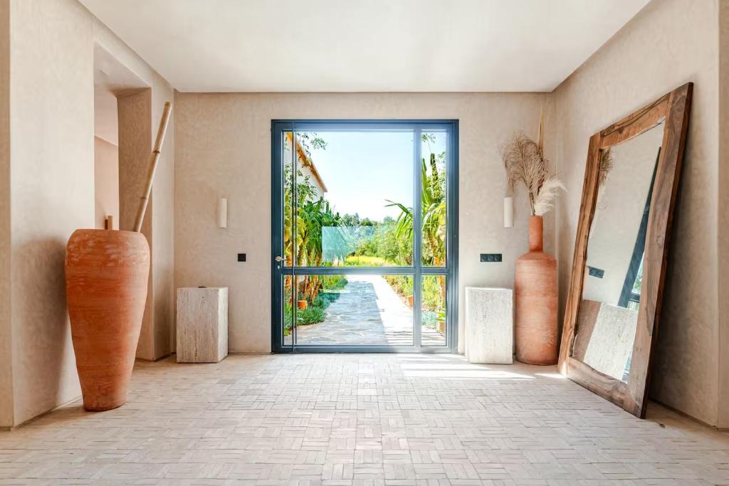 a hallway with an open door with vases at Boucle d'Or in El Mtougui